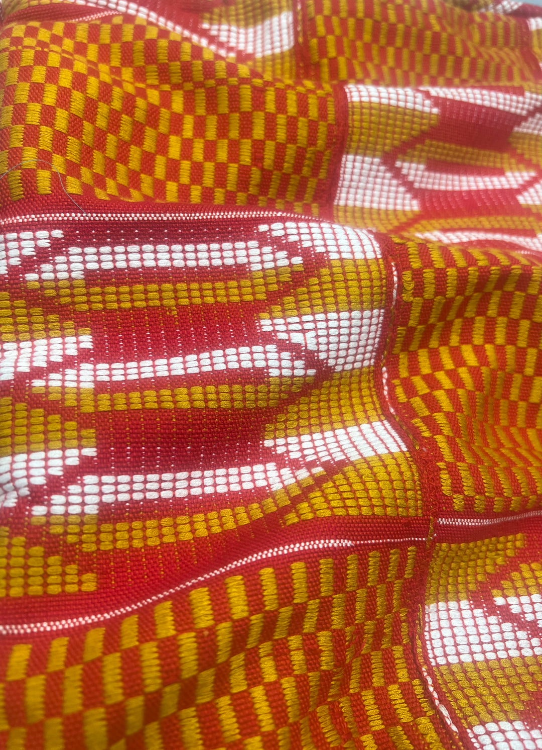 The vibrant Kente patterns featured on the pillow are a celebration of Ghanaian culture and craftsmanship. 